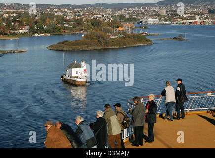 (Dpa) - Passagiere stehen an der Schiene an Deck genießen Sie den Blick auf die Stadt von der Luxus-Fähre Schiff "Color Fantasy" verlässt den Hafen von Oslo, Norwegen, 24. Oktober 2006. In der Mitte ist das Sommer-Restaurant befindet sich im Wasser erreichbar nur per Taxiboot. Die Ansicht stammt von der Fähre Luxusschiff "Color Fantasy" von der Reederei Color auf der Strecke von Oslo, Norwegen Stockfoto