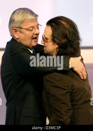 Der ehemalige deutsche Außenminister Joschka Fischer umarmt Bono (R), lead-Sänger der irischen Rockband U2, nach der Siegerehrung für die deutschen Medien 2005 auf der Convention in Baden-Baden, Deutschland, Dienstag, 24. Januar 2006. Fischer hielt die honourific Rede zu Ehren von Bono. Die 45 Jahre alte Sängerin und Kämpferin wurde ausgezeichnet mit dem deutschen Medienpreis, ausgestattet mit 81.000 Stockfoto