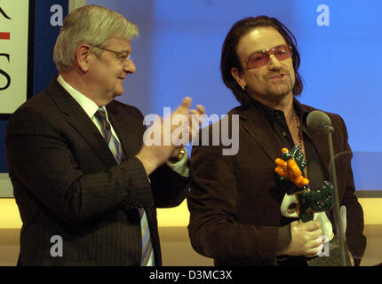 Der ehemalige deutsche Außenminister Joschka Fischer lobt Bono (R), Lead-Sänger der irischen Rockband U2, nach übergibt ihm die Trophäe bei der Siegerehrung für die deutschen Medien 2005 auf der Convention in Baden-Baden, Deutschland, Dienstag, 24. Januar 2006.  Fischer hielt die honourific Rede zu Ehren von Bono. Die 45 Jahre alte Sängerin und Kämpferin wurde ausgezeichnet mit dem deutschen mich Stockfoto
