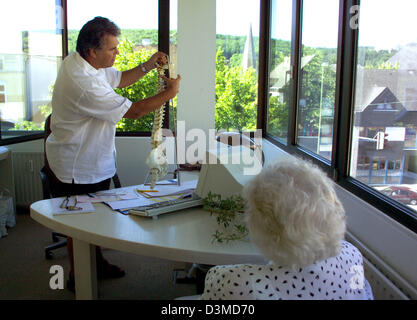 (Datei) - ein Neurologe erklärt Wege zu einem Modell einer menschlichen Wirbelsäule ein älterer Patienten während einer Operation in Iserlohn, Deutschland, 23. Juni 2005. Foto: Klaus Rose Stockfoto