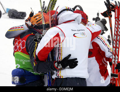 Deutsche Langläufer Jens Filbrich (L), Tobias Angerer überdacht (), Rene Sommerfeldt (R) und Andreas Schluetter (C) Umarmung nach dem zweiten Platz in der 4 x 10 Langlauf Staffelwettkampf bei cross-country Olympiastrecke in Pragelato Plan in der Nähe von Turin, Italien, Sonntag, 19. Februar 2006. Schweden gewann Bronze, Italien Gold. Die XX. Olympischen Winterspiele in Italien laufen von 10 Februar t Stockfoto