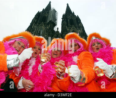 Frauen gekleidet in Kostümen und Perücken Toast an der Kamera vor dem Dom in Köln, Deutschland, Donnerstag, 23. Februar 2006. Karneval des Frauentages kündigt Beginn der Straße Carnaval für mehr als zehn Tausende von Karneval-Enthusiasten in der Rhein-Region. Foto: Oliver Berg Stockfoto