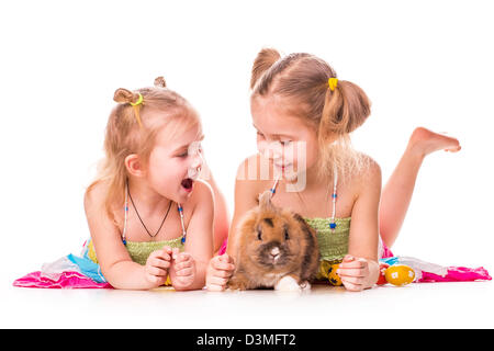 Zwei glückliche Kinder mit Osterhasen und Eiern isoliert auf weiss. Frohe Ostern Stockfoto