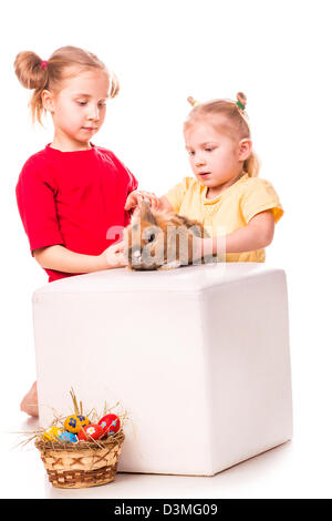 Zwei glückliche Kinder mit Osterhasen und Eiern isoliert auf weiss. Frohe Ostern Stockfoto