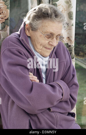 Ältere Frau trägt eine Fleece-Jacke & einen warmen Schal versucht, bei kaltem Wetter warm zu halten Stockfoto