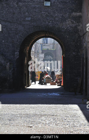 Blick durch alte Bogen in Richtung kleine Geschäfte und Arbeiter in die mittelalterlichen Mauern umgebene Stadt Essaouira an der atlantischen Küste von Marokko Stockfoto