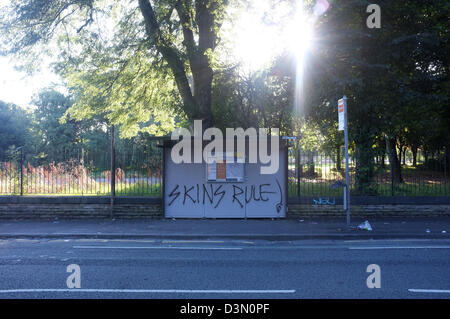 Skinhead Graffiti an einer Bushaltestelle neben Alexandra Park in Manchester. Stockfoto