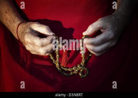 Old mans Händen mit indischen Rudraksha / Japa Mala Gebetskette Stockfoto