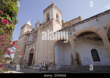 Frau verkaufen Kerzen und religiöse Bilder Iglesia de San Pedro y San Pablo in Villa de Etla, Oaxaca, Mexiko. Stockfoto