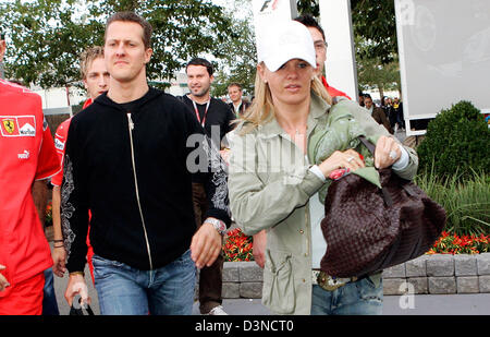 Deutsche Formel1-Fahrer Michael Schumacher (R) für Scuderia Ferrari und seine Frau Corinna (L) verlässt das Fahrerlager nach der australischen Formel Eins Grand Prix auf dem Stadtkurs Albert Park in Melbourne, Australien, Samstag, 1. April 2006. Schumacher schied das Rennen. Foto: Rainer Jensen Stockfoto