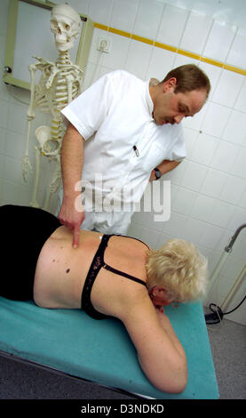 Ein Orthopäde untersucht die Schultern und die Wirbelsäule einer Frau, die auf einer Bahre in eine orthopädische Chirurgie in Iserlohn, Deutschland, 24. Januar 2006 liegt. Foto: Klaus Rose Stockfoto