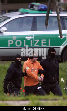 Polizisten führen einen der beiden Verdächtigen an den Hubschrauber nach ein Vollstreckungsbescheid Habeas-Corpus-an den Bundesgerichtshof (BGH) in Karlsruhe, Deutschland, 21. April 2006. Der Mann wird wegen Mordes untersucht Anschlag auf ein Deutsch-äthiopischen in Potsdam, Deutschland angeblich zerschlagen und gefährlich verletzt ihn. Foto: Uli Deck Stockfoto