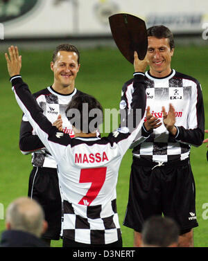 Deutsche Formel1 Rennfahrer Michael Schumacher (L) von Ferrari und Matteo Montezemolo (R), der Sohn von Fiat und Ferrari-Präsident Luca di Montezemolo, veranlasst brasilianische F1-Pilot Felipe Massa (Ferrari), wie er eine Trophäe vor ein Benefiz-Fußballspiel in Ravenna, Italien, 19. April 2006 zeigt. Einige Formel-1-Rennfahrer spielen in einer Charity Fußball Match vor dem Grand Prix von San Marino, die Stockfoto