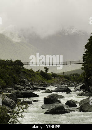 Ein Junge kreuzt eine Hängebrücke über den Fluss Matukituki; Rob Roy Glacier Track, Mt Aspiring National Park, Neuseeland Stockfoto