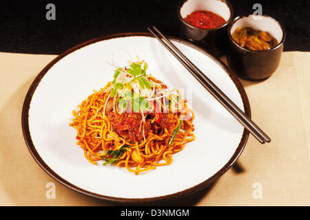 Wok gebratene Szechuan Huhn auf einem Bett aus Nudeln Stockfoto