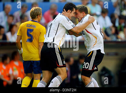 Der deutsche Stürmer Miroslav Klose schmiegt sich die Torschütze Lukas Podolski in der zweiten Vorrundenspiel der WM 2006 zwischen Schweden und Deutschland in München, Deutschland, Samstag, 24. Juni 2006. Deutschland gewann 2:0. Erik Edman entnehmen bitte der linken Seite. Foto: Dpa +++ Mobile Dienste, +++ entnehmen Sie bitte den allgemeinen Geschäftsbedingungen der FIFA Stockfoto