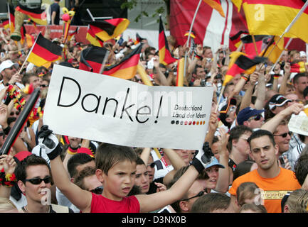 Ein kleiner Junge hält ein Schild, das "Danke" (danke) liest, während Tausende von Fans auf die Ankunft der deutschen Fußball-Nationalmannschaft auf die so genannte "Fan-Meile" in der Nähe Brandenburger Tor in Berlin, Deutschland, Sonntag, 9. Juli 2006 warten. Deutschland gewinnt den dritten Platz in der FIFA-WM 2006 nach dem Sieg über Portugal mit 3: 1. Foto: Miguel Villagran Stockfoto