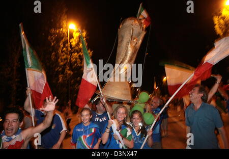 Unterstützer von Italien feiern mit einer Nachbildung des FIFA WM-Pokal in München am Sonntag, 9. Juli 2006. Italien gewann seinen vierten WM-Titel. Foto: Frank Leonhardt Stockfoto