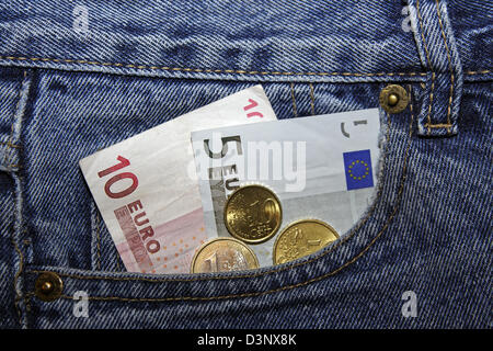 Das Foto zeigt eine fünf und zehn Euro Hinweis und mehrere Münzen in der Tasche eine blaue Jeans in Deutschland, 4. Februar 2006. Foto: Lars Halbauer Stockfoto