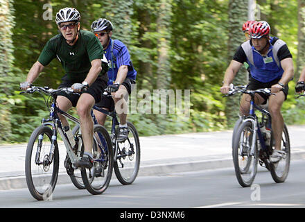 US-Präsident George W. Bush fährt Mountainbike in Heiligendamm, Deutschland, Donnerstag, 13. Juli 2006. Bush wird von mehreren Sicherheitsbeamten auf Fahrrädern und fast ein Dutzend schwarze Limousinen begleitet. Die Tour dauerte ca. 45 Minuten durch den Wald in der Nähe von Heiligendamm, wo Bush während seines Besuchs in Mecklenburg-Vorpommern vom 12. Juli bis 14. Juli 2006 wohnt. Foto: Jan Woitas Stockfoto
