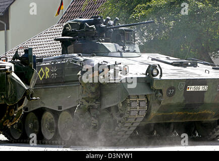 Ein Soldat nimmt Tarnung hinter einem Tank und Ziele im Training Dorf "Bonnland" Hammelburg, Deutschland, 11. Juli 2006. Soldaten der verschiedenen internationalen Intervention zwingen Unternehmen Manöver eine Haussammlungen kämpfenden Routine für Auslandseinsätze. Infanterie-Schule in der deutschen Streitkräfte UN Training Centre Züge etwa 30.000 Soldaten pro Jahr von denen weitere 50 pro Stockfoto