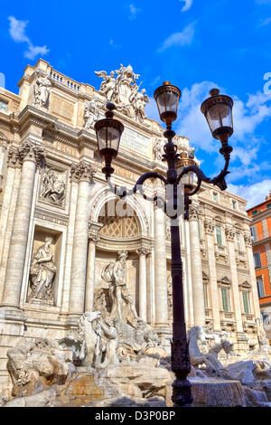 Vertikal ausgerichtete Bild des typischen römischen Laternenpfahl und berühmten Trevi-Brunnen unter blauem Himmel in Rom, Italien. Stockfoto