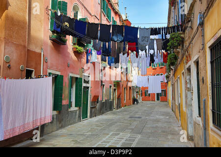 Trocknen von Kleidung hängen zum Trocknen auf eine Wäscheleine in einer Straße am Waschtag in Venedig, Italien Stockfoto