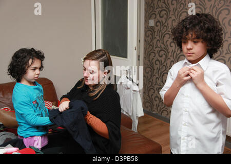 Junge Mutter, die immer ihre beiden Kinder bereit für die Schule am Morgen, UK Stockfoto