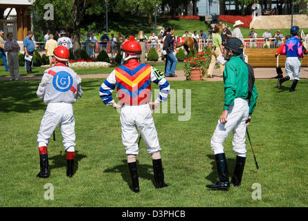 Drei Jockey ist warten auf Koppel Rasen für Montierungen, satteln Stände zu verlassen. Stockfoto