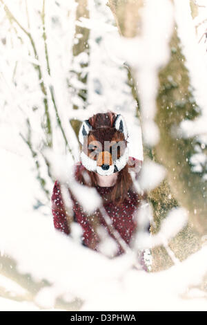 Frau trägt eine Maskierung Fuchs im Schnee Stockfoto