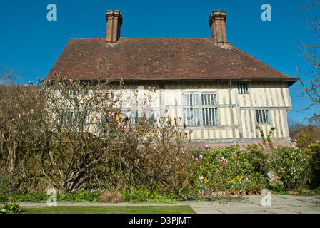 Great Dixter historischen 15. Jahrhundert Haus Magnolien und Sträucher im Frühling, blauer Himmel. Lange Grenze. Stockfoto