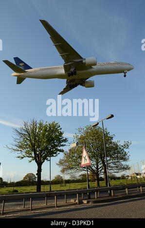 Saudi Arabian Airlines Boeing 777 Flugzeug HZ-AKI landet am Flughafen London Heathrow über der A30 mit Warnschild Stockfoto