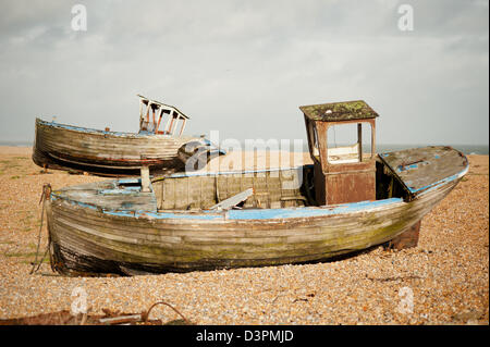 Alte verlassene hölzerne Fischerboote auf dem Kiesstrand bei Dungeness in Kent, UK. Stockfoto