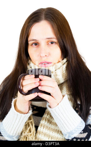 Junge Frau gefangen kalt, eingehüllt in Decke, trinken etwas warmes aus Tasse. Stockfoto