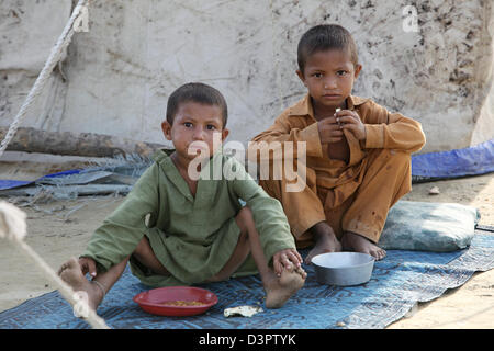 Nowshera, Pakistan, zwei Jungs sitzen vor einem Zelt Stockfoto