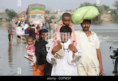 Muzaffergar, Pakistan, Menschen durch überflutete Straßen durch waten Stockfoto