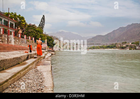 Hinduistischer Mönch am Ghat der heiligen Fluss Ganges, Ram Jhula, Rishikesh, Uttarakhand, Indien Stockfoto