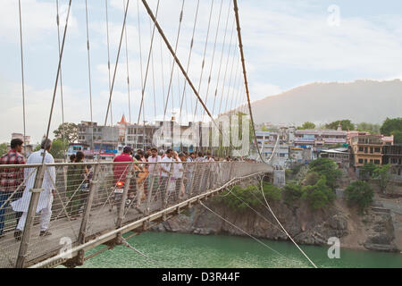 Touristen stehen auf einer Hängebrücke Lakshman Jhula, Fluss Ganges, Rishikesh, Dehradun Bezirk, Uttarakhand, Indien Stockfoto