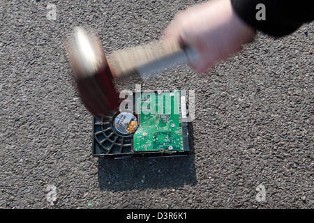 Ein Hammer auf einer PC-Festplatte in einem Versuch zu verhindern, dass Daten gestohlen werden. Stockfoto