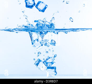 Ice Cubes fiel ins Wasser mit Spritzen auf weiß Stockfoto