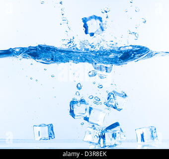 Ice Cubes fiel ins Wasser mit Spritzen auf weiß Stockfoto