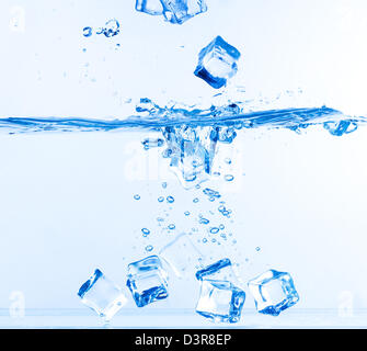 Ice Cubes fiel ins Wasser mit Spritzen auf weiß Stockfoto