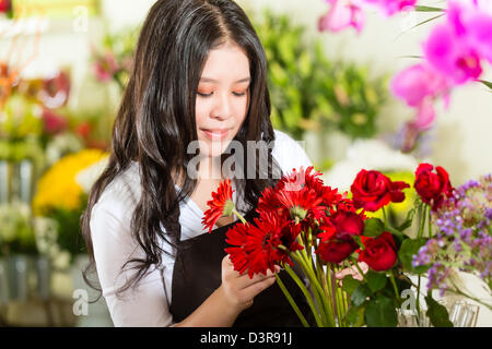 Freundliche asiatische Floristin oder Verkäuferin in einem Blumenladen Stockfoto