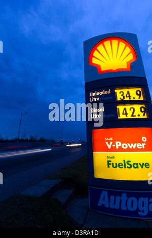 Shell Kraftstoff Preis Zeichen ist nachts beleuchtet. Autos auf der Straße entlang verlassen Lichtspuren. Stockfoto