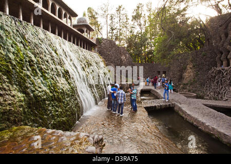 Menschen genießen in einem Wasserfall am Rock Garten von Nek Chand Saini, Steingarten von Chandigarh, Indien Stockfoto