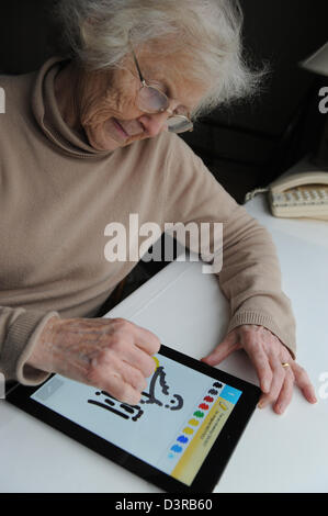 77 Jahre alte Großmutter spielen der Auslosung etwas Spiel auf einem Apple Ipad. Stockfoto