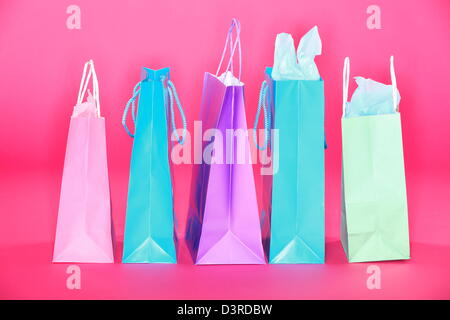 Gruppe von bunten einkaufen Papiertüten auf rosa Boden isoliert auf rosa Hintergrund Stockfoto