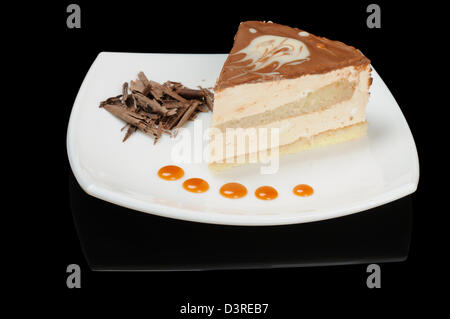 Kuchen auf weißen Teller auf schwarzem Hintergrund Stockfoto