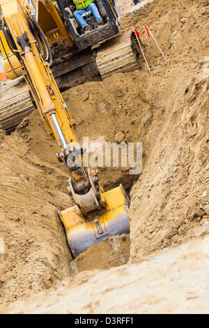 Arbeiten Bagger Traktor einen Graben. Stockfoto