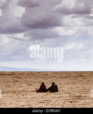 Masai Kinder sitzen in der Savanne Blick in die weite Ferne von der Serengeti-Ebene. Tansania Stockfoto